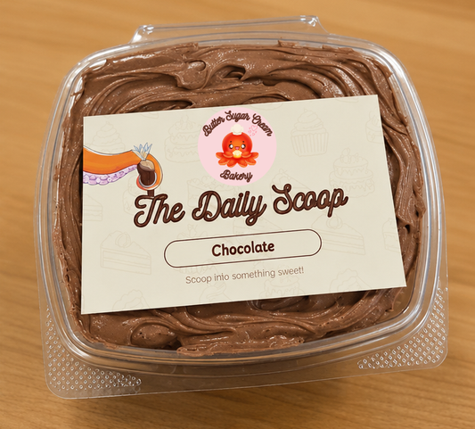 Container of chocolate cake with chocolate frosting with 'The Daily Scoop' label on a wooden surface